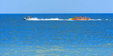 Odessa, Ukrayna - 8 Ağustos 2018. Turistler eğleniyor ve scooter deniz yoluyla taşıma kırmızı ve sarı şişme muz, binme keyfini çıkarın. Yaz tatili, tatil ve seyahat kavramı