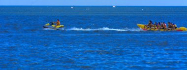 Odessa, Ukrayna - 8 Ağustos 2018. Turistler eğleniyor ve scooter deniz yoluyla taşıma kırmızı ve sarı şişme muz, binme keyfini çıkarın. Yaz tatili, tatil ve seyahat kavramı