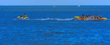 Odessa, Ukrayna - 8 Ağustos 2018. Turistler eğleniyor ve scooter deniz yoluyla taşıma kırmızı ve sarı şişme muz, binme keyfini çıkarın. Yaz tatili, tatil ve seyahat kavramı