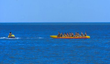 Odessa, Ukrayna - 8 Ağustos 2018. Turistler eğleniyor ve scooter deniz yoluyla taşıma kırmızı ve sarı şişme muz, binme keyfini çıkarın. Yaz tatili, tatil ve seyahat kavramı