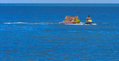 Odessa, Ukrayna - 8 Ağustos 2018. Turistler eğleniyor ve scooter deniz yoluyla taşıma kırmızı ve sarı şişme muz, binme keyfini çıkarın. Yaz tatili, tatil ve seyahat kavramı
