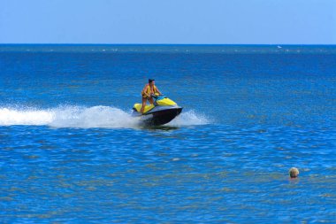 Odessa, Ukrayna - 8 Ağustos 2018. Turistler eğleniyor ve scooter deniz yoluyla taşıma kırmızı ve sarı şişme muz, binme keyfini çıkarın. Yaz tatili, tatil ve seyahat kavramı