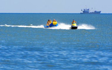 Odessa, Ukrayna - 8 Ağustos 2018. Turistler eğleniyor ve scooter deniz yoluyla taşıma kırmızı ve sarı şişme muz, binme keyfini çıkarın. Yaz tatili, tatil ve seyahat kavramı