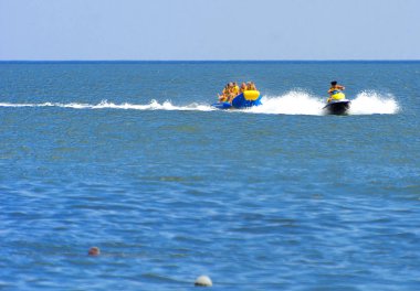 Odessa, Ukrayna - 8 Ağustos 2018. Turistler eğleniyor ve scooter deniz yoluyla taşıma kırmızı ve sarı şişme muz, binme keyfini çıkarın. Yaz tatili, tatil ve seyahat kavramı