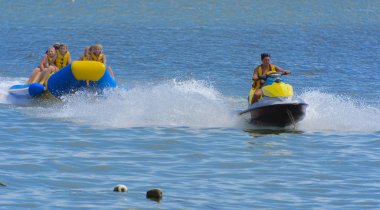 Odessa, Ukrayna - 8 Ağustos 2018. Turistler eğleniyor ve scooter deniz yoluyla taşıma kırmızı ve sarı şişme muz, binme keyfini çıkarın. Yaz tatili, tatil ve seyahat kavramı