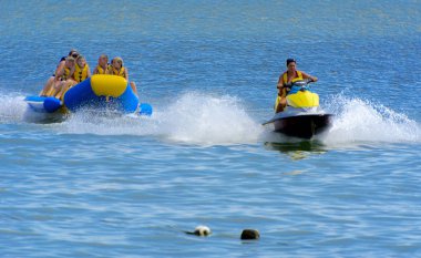 Odessa, Ukrayna - 8 Ağustos 2018. Turistler eğleniyor ve scooter deniz yoluyla taşıma kırmızı ve sarı şişme muz, binme keyfini çıkarın. Yaz tatili, tatil ve seyahat kavramı