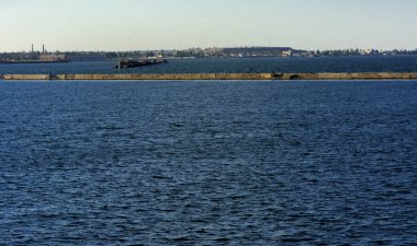 Muhteşem panorama, denizden görünümüne yumuşak güneş ışığı altında gün batımına şehrin kıyı şeridi. Yüksek katlı binalar ve sahilde ticari yapılar