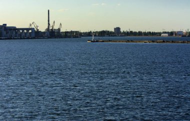 Muhteşem panorama, denizden görünümüne yumuşak güneş ışığı altında gün batımına şehrin kıyı şeridi. Yüksek katlı binalar ve sahilde ticari yapılar