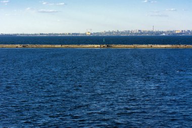 Muhteşem panorama, denizden görünümüne yumuşak güneş ışığı altında gün batımına şehrin kıyı şeridi. Yüksek katlı binalar ve sahilde ticari yapılar