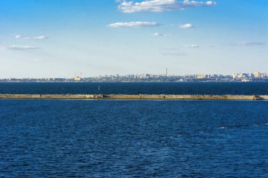 Muhteşem panorama, denizden görünümüne yumuşak güneş ışığı altında gün batımına şehrin kıyı şeridi. Yüksek katlı binalar ve sahilde ticari yapılar