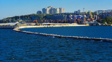 Odessa, Ukrayna - 08 Ağustos 2018. Denizin muhteşem manzara yumuşak bir ışık gün batımından önce şehrin kıyı şeridinde. Yüksek katlı binalar ve sahilde ticari yapılar