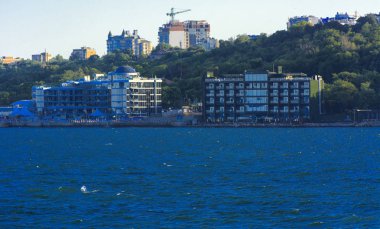 Odessa, Ukrayna - 08 Ağustos 2018. Denizin muhteşem manzara yumuşak bir ışık gün batımından önce şehrin kıyı şeridinde. Yüksek katlı binalar ve sahilde ticari yapılar