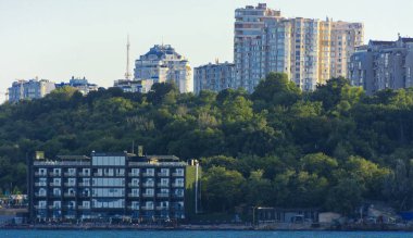 Odessa, Ukrayna - 08 Ağustos 2018. Denizin muhteşem manzara yumuşak bir ışık gün batımından önce şehrin kıyı şeridinde. Yüksek katlı binalar ve sahilde ticari yapılar