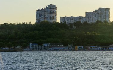 Odessa, Ukrayna - 08 Ağustos 2018. Denizin muhteşem manzara yumuşak bir ışık gün batımından önce şehrin kıyı şeridinde. Yüksek katlı binalar ve sahilde ticari yapılar