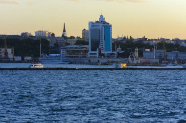 Odessa, Ukrayna - 08 Ağustos 2018. Denizin muhteşem manzara yumuşak bir ışık gün batımından önce şehrin kıyı şeridinde. Yüksek katlı binalar ve sahilde ticari yapılar