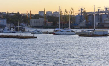Odessa, Ukrayna - 08 Ağustos 2018. Denizin muhteşem manzara yumuşak bir ışık gün batımından önce şehrin kıyı şeridinde. Yüksek katlı binalar ve sahilde ticari yapılar