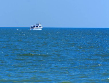 Odessa, Ukrayna - 08 Ağustos 2018. Açık denizde yürüyüşleri için mavi gökyüzü karşı yumuşak güneş ışığı akşam gemi. Yaz macera, tatil, etkin yaz tatil kavramı üzerinde Karadeniz, Ukrayna
