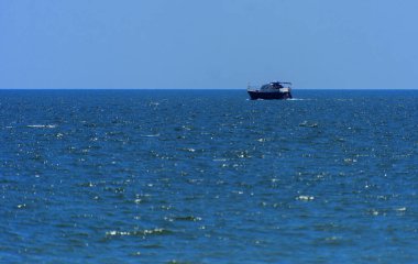 Odessa, Ukrayna - 08 Ağustos 2018. Açık denizde yürüyüşleri için mavi gökyüzü karşı yumuşak güneş ışığı akşam gemi. Yaz macera, tatil, etkin yaz tatil kavramı üzerinde Karadeniz, Ukrayna