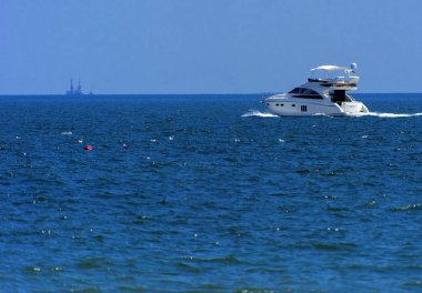 Odessa, Ukrayna - 08 Ağustos 2018. Açık denizde yürüyüşleri için mavi gökyüzü karşı yumuşak güneş ışığı akşam gemi. Yaz macera, tatil, etkin yaz tatil kavramı üzerinde Karadeniz, Ukrayna