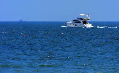 Odessa, Ukrayna - 08 Ağustos 2018. Açık denizde yürüyüşleri için mavi gökyüzü karşı yumuşak güneş ışığı akşam gemi. Yaz macera, tatil, etkin yaz tatil kavramı üzerinde Karadeniz, Ukrayna