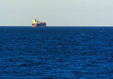 Odessa, Ukrayna - 08 Ağustos 2018. Bir büyük kargo gemisi açık denizde akşam yumuşak güneş ışığı altında mavi gökyüzü karşı konteyner taşımaları. Karadeniz, Ukrayna navlun trafik kavramı.