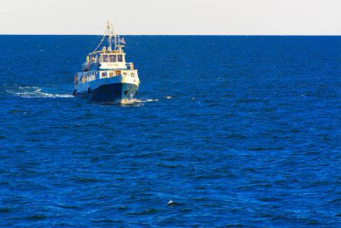 Odessa, Ukrayna - 08 Ağustos 2018. Açık denizde yürüyüşleri için mavi gökyüzü karşı yumuşak güneş ışığı akşam gemi. Yaz macera, tatil, etkin yaz tatil kavramı üzerinde Karadeniz, Ukrayna