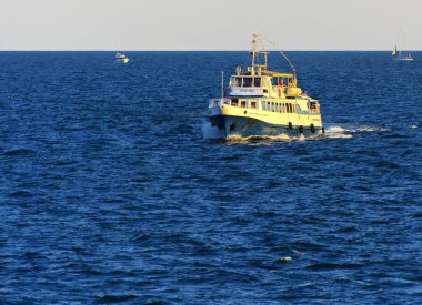 Odessa, Ukrayna - 08 Ağustos 2018. Açık denizde yürüyüşleri için mavi gökyüzü karşı yumuşak güneş ışığı akşam gemi. Yaz macera, tatil, etkin yaz tatil kavramı üzerinde Karadeniz, Ukrayna