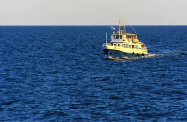 Odessa, Ukrayna - 08 Ağustos 2018. Açık denizde yürüyüşleri için mavi gökyüzü karşı yumuşak güneş ışığı akşam gemi. Yaz macera, tatil, etkin yaz tatil kavramı üzerinde Karadeniz, Ukrayna
