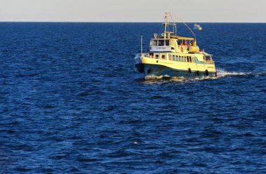 Odessa, Ukrayna - 08 Ağustos 2018. Açık denizde yürüyüşleri için mavi gökyüzü karşı yumuşak güneş ışığı akşam gemi. Yaz macera, tatil, etkin yaz tatil kavramı üzerinde Karadeniz, Ukrayna