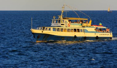 Odessa, Ukrayna - 08 Ağustos 2018. Açık denizde yürüyüşleri için mavi gökyüzü karşı yumuşak güneş ışığı akşam gemi. Yaz macera, tatil, etkin yaz tatil kavramı üzerinde Karadeniz, Ukrayna