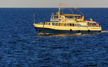 Odessa, Ukrayna - 08 Ağustos 2018. Açık denizde yürüyüşleri için mavi gökyüzü karşı yumuşak güneş ışığı akşam gemi. Yaz macera, tatil, etkin yaz tatil kavramı üzerinde Karadeniz, Ukrayna