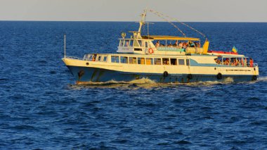 Odessa, Ukrayna - 08 Ağustos 2018. Açık denizde yürüyüşleri için mavi gökyüzü karşı yumuşak güneş ışığı akşam gemi. Yaz macera, tatil, etkin yaz tatil kavramı üzerinde Karadeniz, Ukrayna