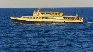 Odessa, Ukrayna - 08 Ağustos 2018. Açık denizde yürüyüşleri için mavi gökyüzü karşı yumuşak güneş ışığı akşam gemi. Yaz macera, tatil, etkin yaz tatil kavramı üzerinde Karadeniz, Ukrayna