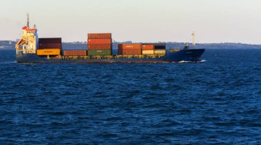 Odessa, Ukrayna - 08 Ağustos 2018. Bir büyük kargo gemisi açık denizde akşam yumuşak güneş ışığı altında mavi gökyüzü karşı konteyner taşımaları. Karadeniz, Ukrayna navlun trafik kavramı.