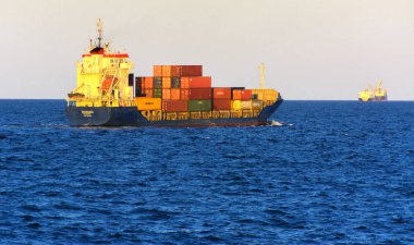 Odessa, Ukrayna - 08 Ağustos 2018. Bir büyük kargo gemisi açık denizde akşam yumuşak güneş ışığı altında mavi gökyüzü karşı konteyner taşımaları. Karadeniz, Ukrayna navlun trafik kavramı.