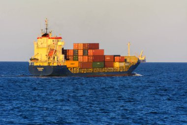 Odessa, Ukrayna - 08 Ağustos 2018. Bir büyük kargo gemisi açık denizde akşam yumuşak güneş ışığı altında mavi gökyüzü karşı konteyner taşımaları. Karadeniz, Ukrayna navlun trafik kavramı.