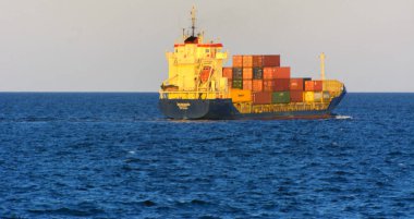 Odessa, Ukrayna - 08 Ağustos 2018. Bir büyük kargo gemisi açık denizde akşam yumuşak güneş ışığı altında mavi gökyüzü karşı konteyner taşımaları. Karadeniz, Ukrayna navlun trafik kavramı.