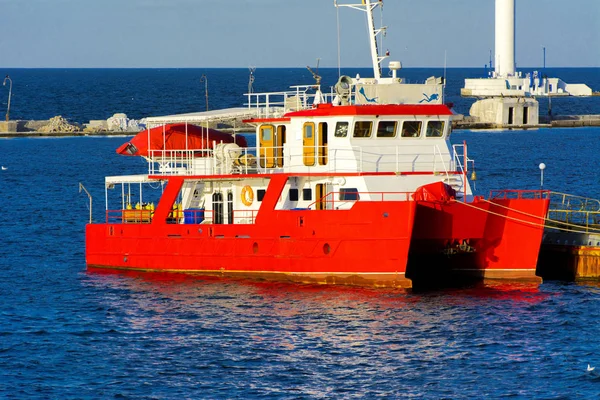 公開した海で海散歩に壮大な赤い双胴船は夕方の柔らかい日光の桟橋近くに係留されました ウクライナ黒海の夏の冒険 アクティブな夏の休日の概念 — ストック写真