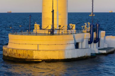 Alt kısmında bir güzel akşam mavi gökyüzü yumuşak renklerde arka plan üzerinde bağlantı noktası girişinde deniz feneri. Yaz deniz manzarası. Bir kırmızı top ile beyaz deniz feneri. Karadeniz. Odessa Limanı