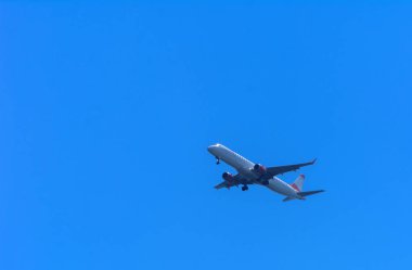 Bir uçak gökyüzünde büyük kanat yüksek büyük yolcu uçağıdır. Taşıma turistler için mavi gökyüzü ve beyaz bulutlar karşı egzotik tatil