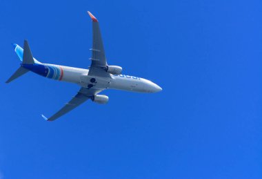 Bir uçak gökyüzünde büyük kanat yüksek büyük yolcu uçağıdır. Taşıma turistler için mavi gökyüzü ve beyaz bulutlar karşı egzotik tatil