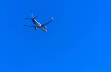 Bir uçak gökyüzünde büyük kanat yüksek büyük yolcu uçağıdır. Taşıma turistler için mavi gökyüzü ve beyaz bulutlar karşı egzotik tatil