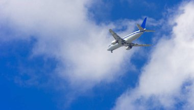 Bir uçak gökyüzünde büyük kanat yüksek büyük yolcu uçağıdır. Taşıma turistler için mavi gökyüzü ve beyaz bulutlar karşı egzotik tatil