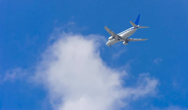 大型旅客機は 空に大きな翼高平面です 青い空と白い雲とエキゾチックな休日の観光客の輸送 — ストック写真