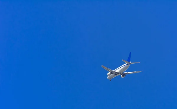 大型旅客機は 空に大きな翼高平面です 青い空と白い雲とエキゾチックな休日の観光客の輸送 — ストック写真