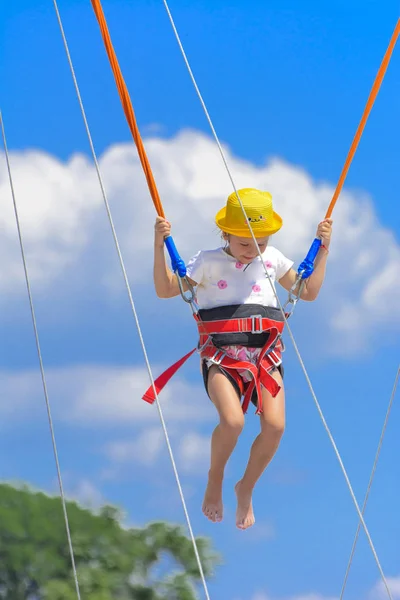 Маленькая Девочка Прыгает Высоко Батуте Резиновыми Веревками Против Голубого Неба — стоковое фото