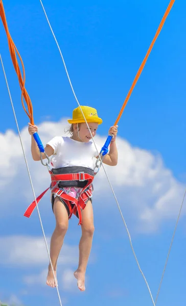 Little Girl Jumps High Trampoline Rubber Ropes Blue Sky White — Stock Photo, Image
