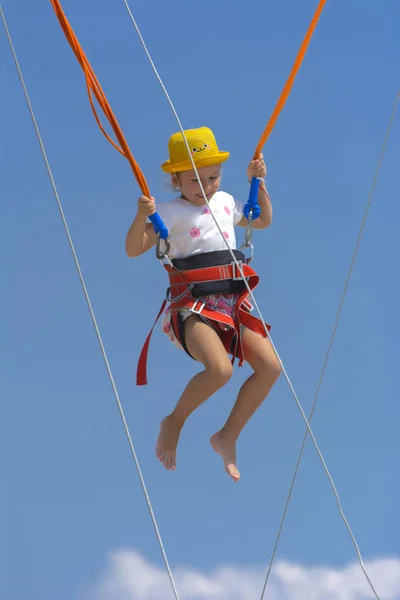 Een Klein Meisje Springt Hoog Een Trampoline Met Rubber Touwen — Stockfoto
