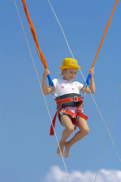 Une Petite Fille Saute Haut Sur Trampoline Avec Des Cordes — Photo