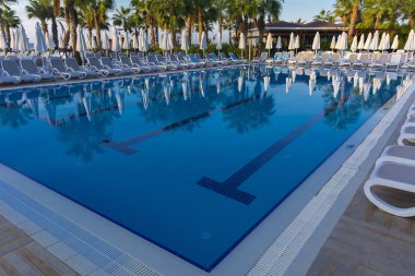 Alanya, Türkiye - 05 Ekim 2018. Kirman Sidera lüks otel ile güzel havuzu temiz deniz, mavi gökyüzü ve yeşil palmiye ağaçları zemin üzerine mavi su. Plaj şezlong, yaz tatili, turizm